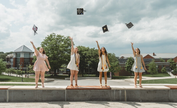 Mädchen werfen Absolventenkappen in die Luft