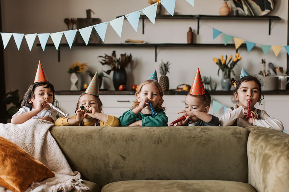 Kinder mit Partyhüten und Tröten